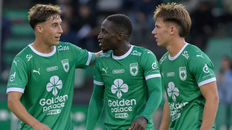 Drie spelers van RAAL La Louvière in groen tenue tijdens een korte onderbreking op het veld.