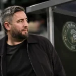 Lee Johnson in donkere jas aan de technische zone van Lommel SK.