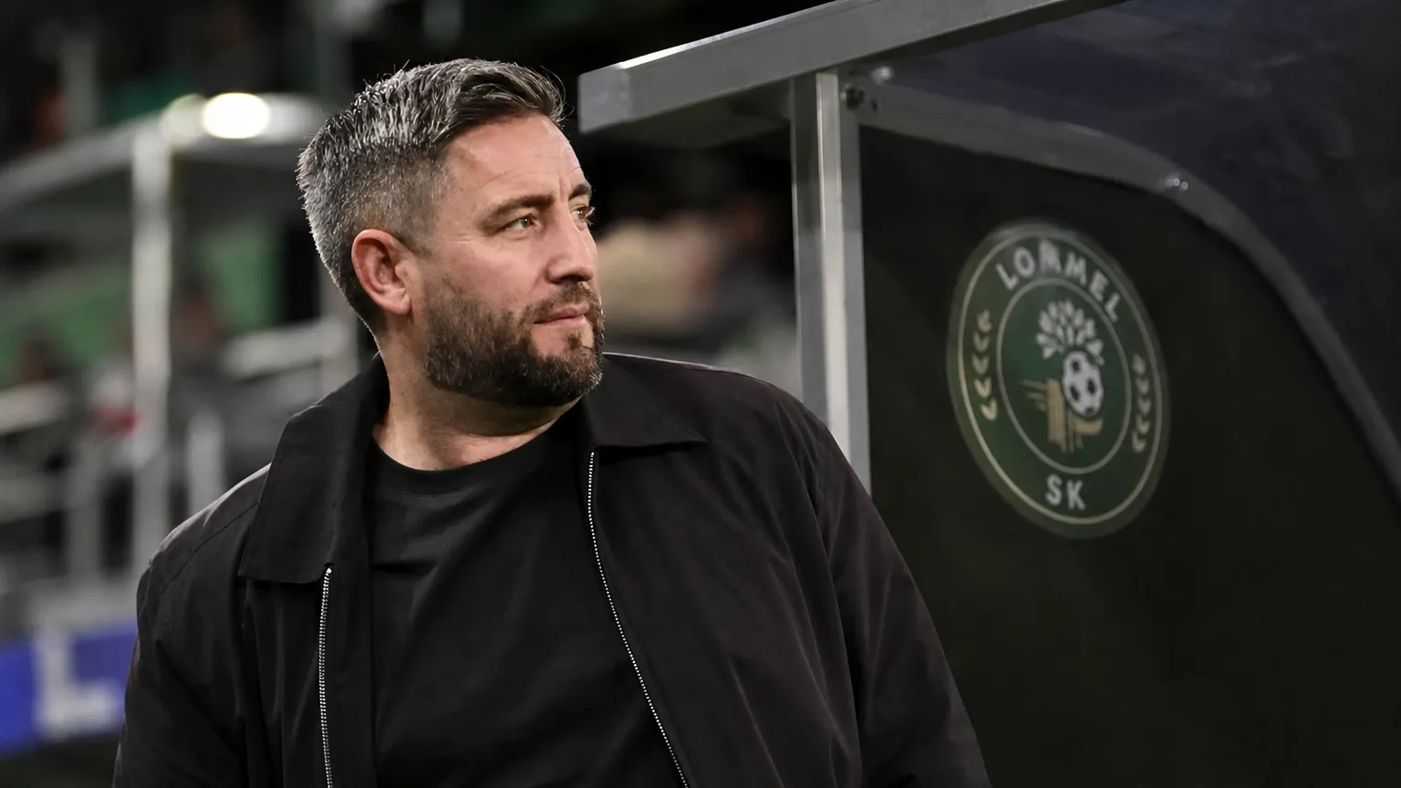 Lee Johnson in donkere jas aan de technische zone van Lommel SK.