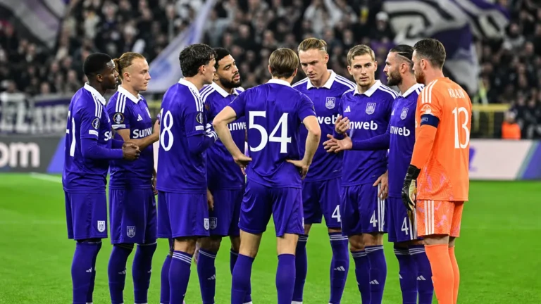 Een groep Anderlecht-spelers in paarse wedstrijdtenues verzamelt zich op het veld voor de aftrap.