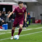 Mert Kömür in actie voor FC Augsburg met de bal aan de voet.