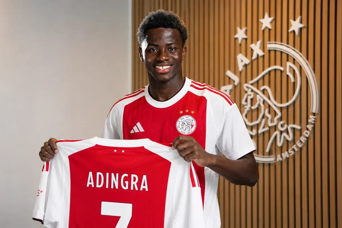 Simon Adingra poseert tijdens een officiële Ajax-shirtpresentatie.