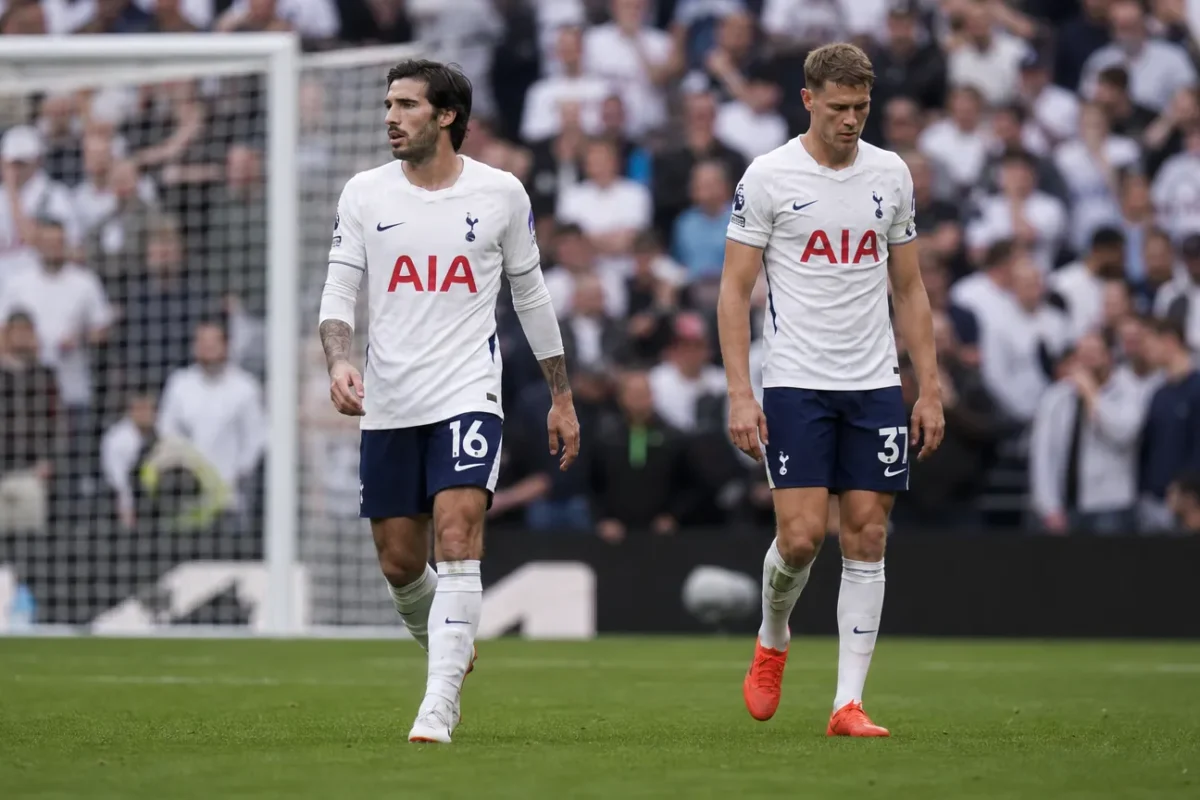 Twee Tottenham-spelers lopen na de wedstrijd over het veld voor het doel.