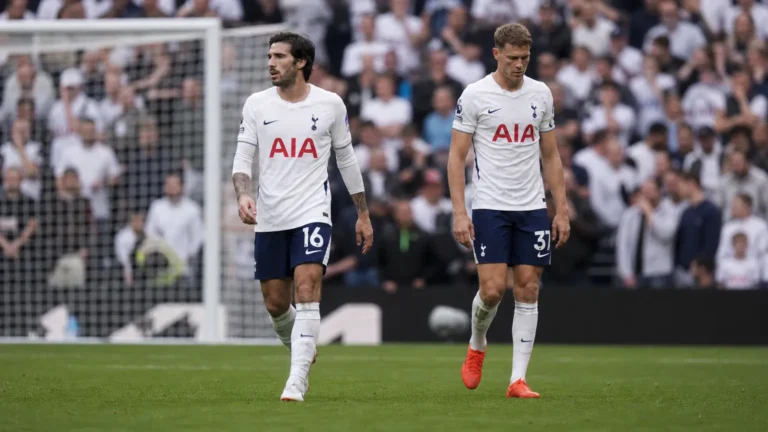 Twee Tottenham-spelers lopen na de wedstrijd over het veld voor het doel.