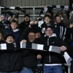 Jubelende Eupen-supporters met sjaals in de tribune na de derbyzege.