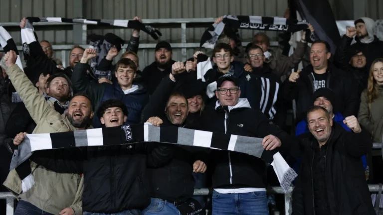 Jubelende Eupen-supporters met sjaals in de tribune na de derbyzege.