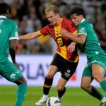 Spelers van KV Mechelen en Lommel in een fysiek duel op het veld.