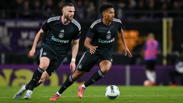 Twee Anderlecht-spelers in donkere wedstrijdshirts tijdens een wedstrijdactie.