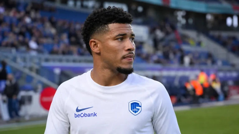 Kevin Amaro in een wit KRC Genk-tenue langs het veld.