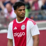 Owen Wijndal in het wit-rode shirt van Ajax naast het veld.