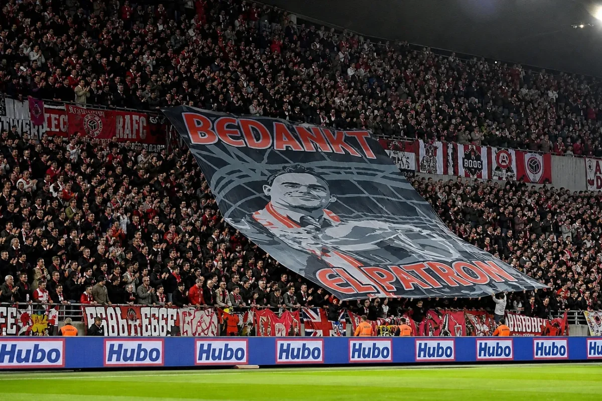 Een volle Antwerpse tribune met rood-witte supporters en een grote tifo op de Bosuil.