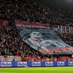 Een volle Antwerpse tribune met rood-witte supporters en een grote tifo op de Bosuil.