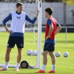 Twee voetballers tijdens een oefensessie naast een verplaatsbaar doel.