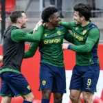 Een groep Union-spelers viert samen langs de zijlijn tijdens een wedstrijd.