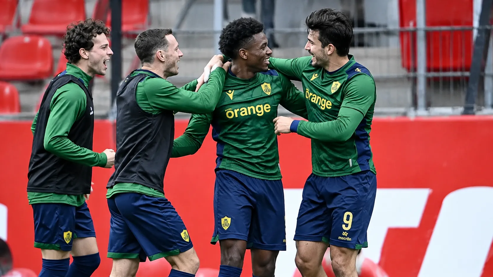 Een groep Union-spelers viert samen langs de zijlijn tijdens een wedstrijd.