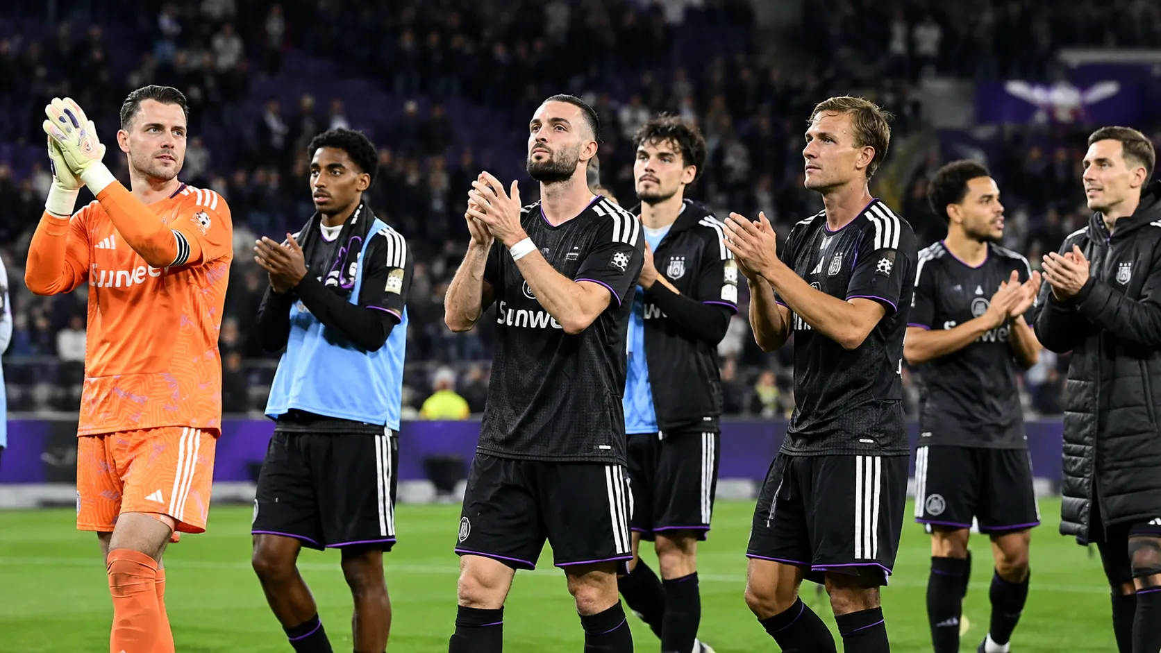 Een groep Anderlecht-spelers applaudisseert na afloop op het veld.