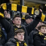 Een collectieve groep Lokeren-supporters in de tribune met een clubsjaal.