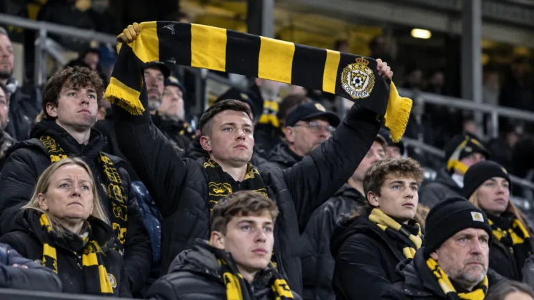 Een collectieve groep Lokeren-supporters in de tribune met een clubsjaal.