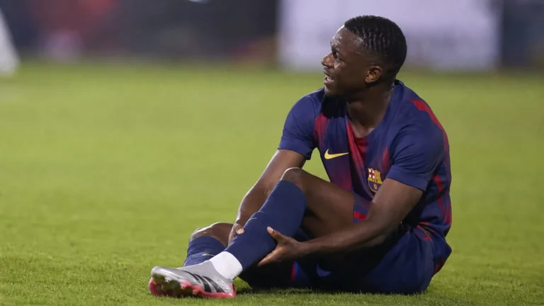 Jesse Bisiwu zit op het gras na een blessure tijdens een voetbalwedstrijd.