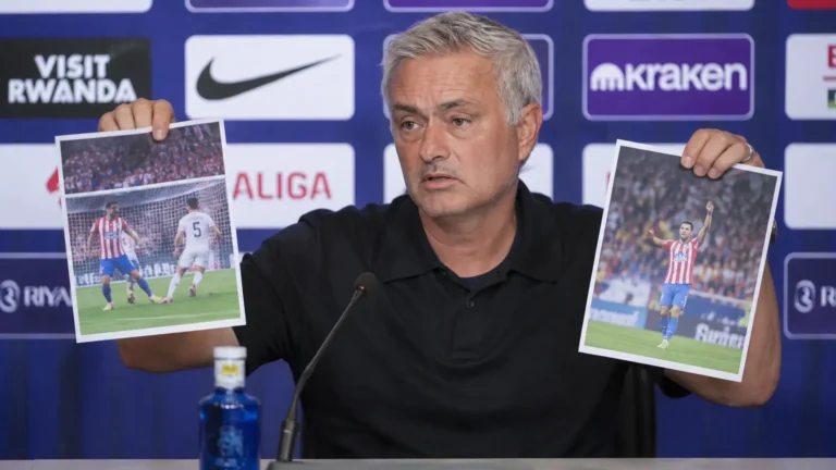 José Mourinho houdt tijdens een persconferentie twee uitgeprinte wedstrijdfoto's omhoog.