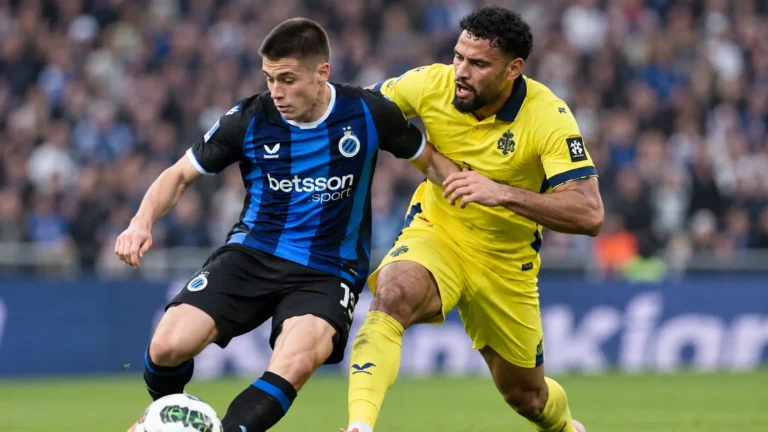 Twee voetballers in blauw-zwart en geel vechten een duel uit op het veld.