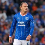 Thelo Aasgaard in het blauw van Rangers aan de rand van het veld.
