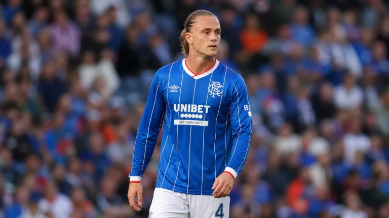 Thelo Aasgaard in het blauw van Rangers aan de rand van het veld.