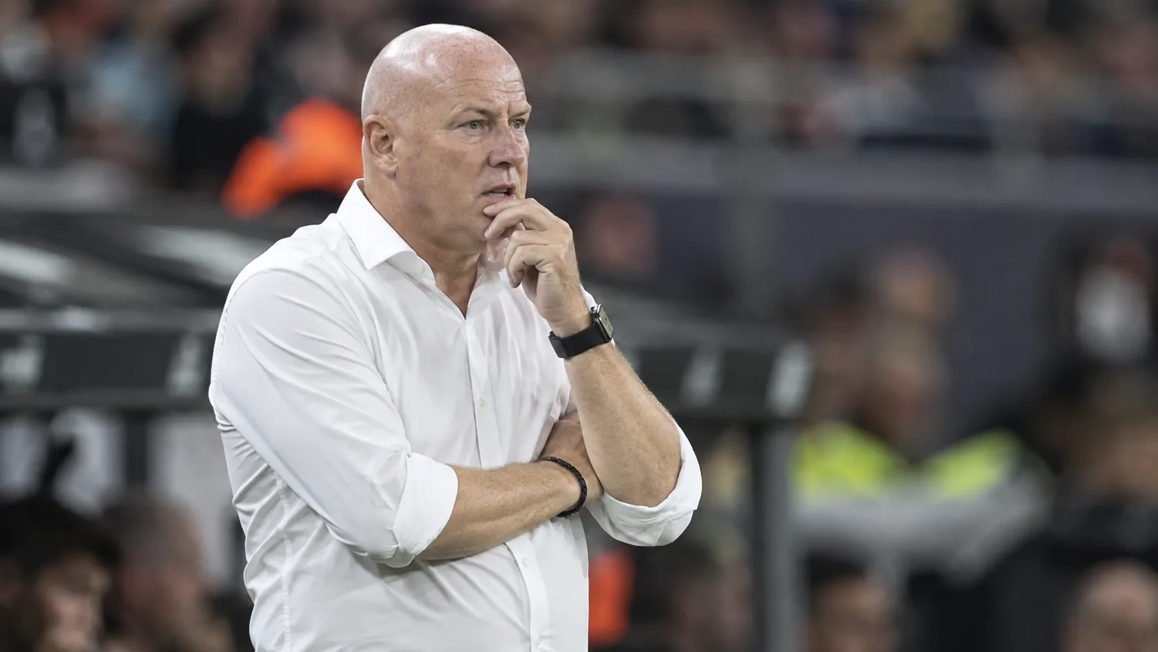 Fred Vanderbiest in een wit hemd langs de zijlijn van een voetbalstadion.