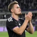 Marten Winkler applaudisseert na een wedstrijd op het voetbalveld.
