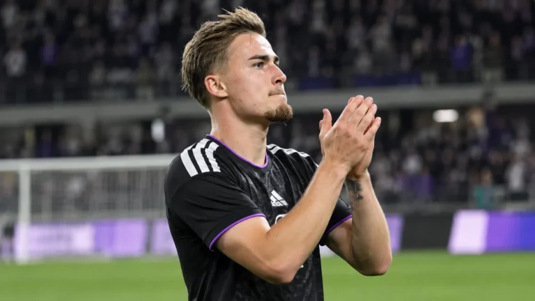 Marten Winkler applaudisseert na een wedstrijd op het voetbalveld.