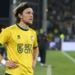 Alen Halilovic in een geel voetbalshirt op een verlicht voetbalveld.