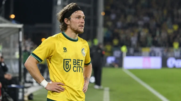 Alen Halilovic in een geel voetbalshirt op een verlicht voetbalveld.