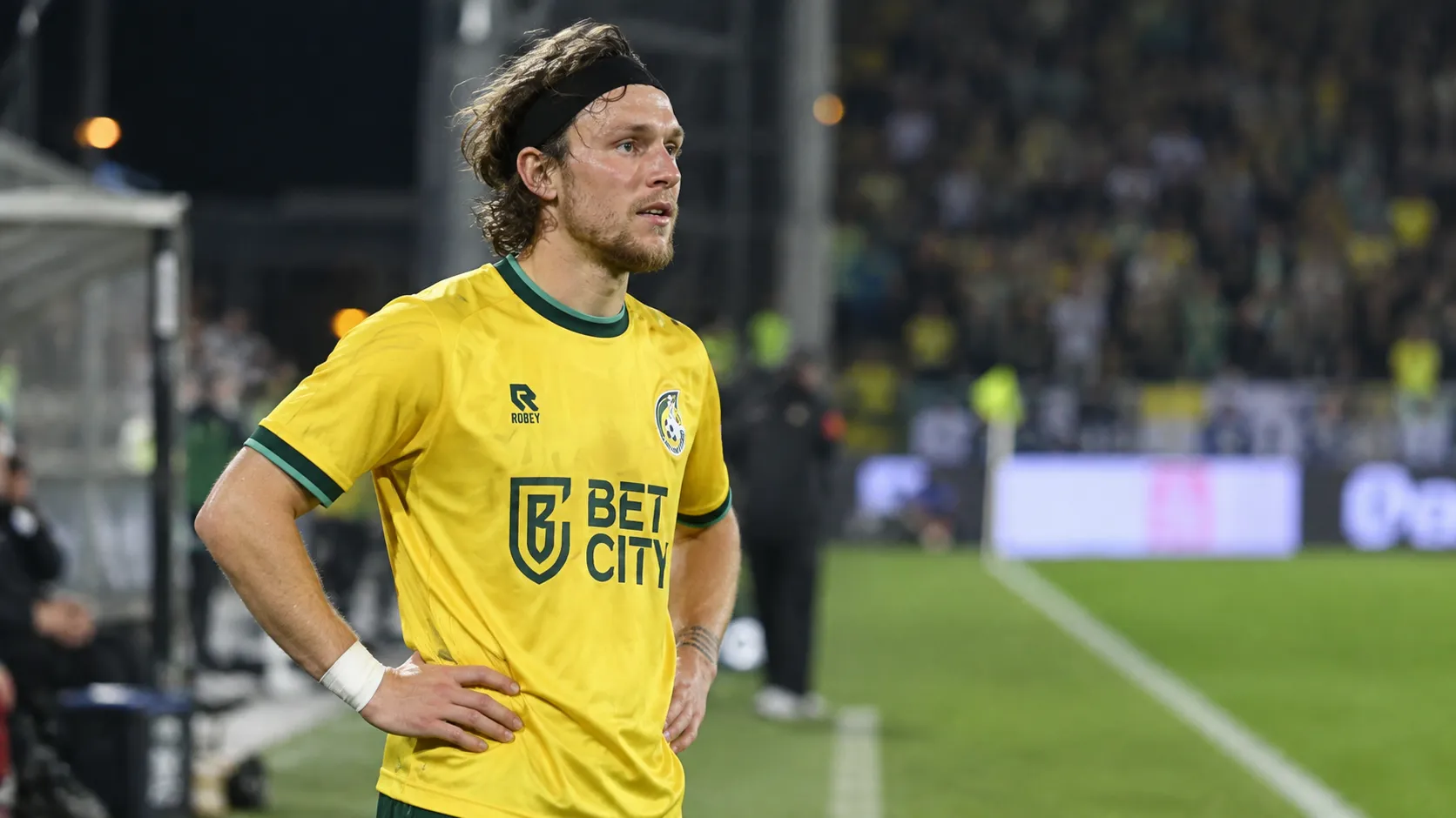 Alen Halilovic in een geel voetbalshirt op een verlicht voetbalveld.