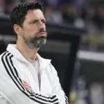 Vitor Bruno kijkt aandachtig vanaf de zijlijn van een voetbalveld.
