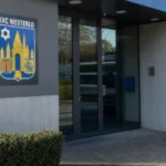 De ingang van een KVC Westerlo-clubgebouw met een fysiek geïntegreerd clubembleem.
