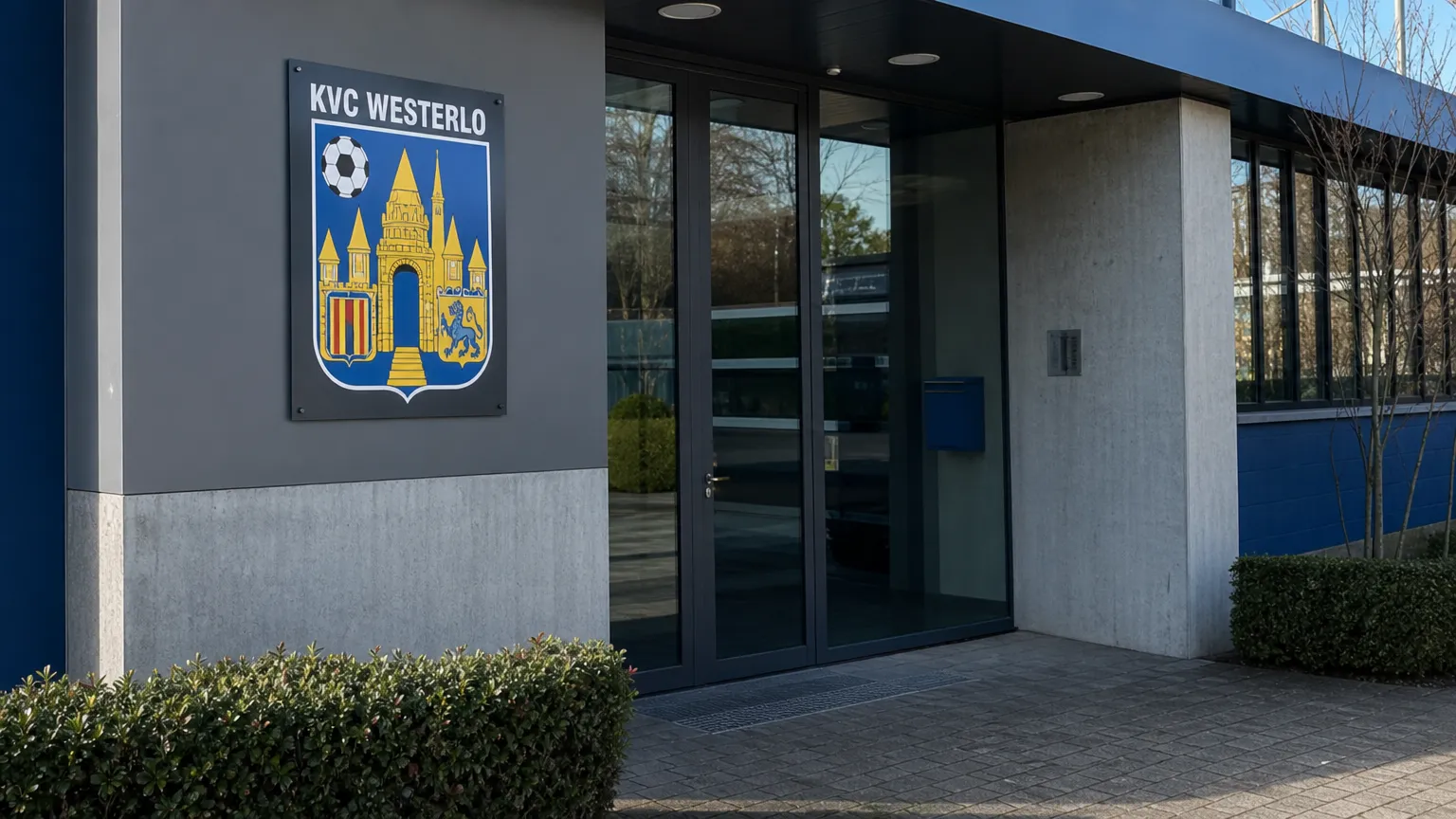 De ingang van een KVC Westerlo-clubgebouw met een fysiek geïntegreerd clubembleem.