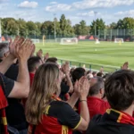 Een collectieve groep supporters applaudisseert tijdens een open training van de Rode Duivels.