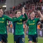 Denzel De Roeve van Union SG wordt na de wedstrijd omringd door ploegmaats op het veld.