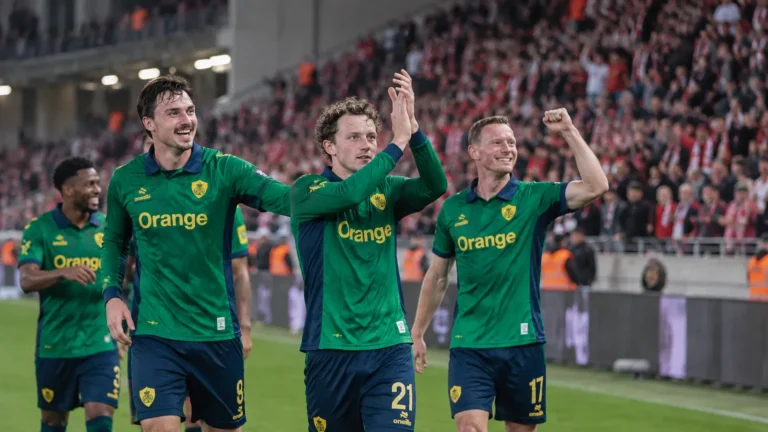 Denzel De Roeve van Union SG wordt na de wedstrijd omringd door ploegmaats op het veld.