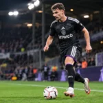 Lukáš Ambros van Anderlecht trapt een bal langs de rechterflank in een avondwedstrijd.