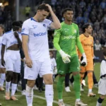 Spelers van Club Brugge en KRC Genk wandelen na de wedstrijd samen van het veld.