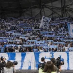 Een grote groep Olympique Marseille-supporters met blauw-witte sjaals in het Vélodrome.