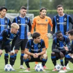 Een groep spelers van Club Brugge verzamelt zich op het veld voor een wedstrijdmoment.