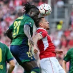 Union-spelers in het groen in een kopduel met een speler van Antwerp.