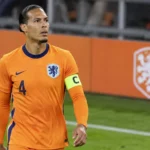 Virgil van Dijk in het tenue van Nederland met aanvoerdersband aan de rand van het veld.