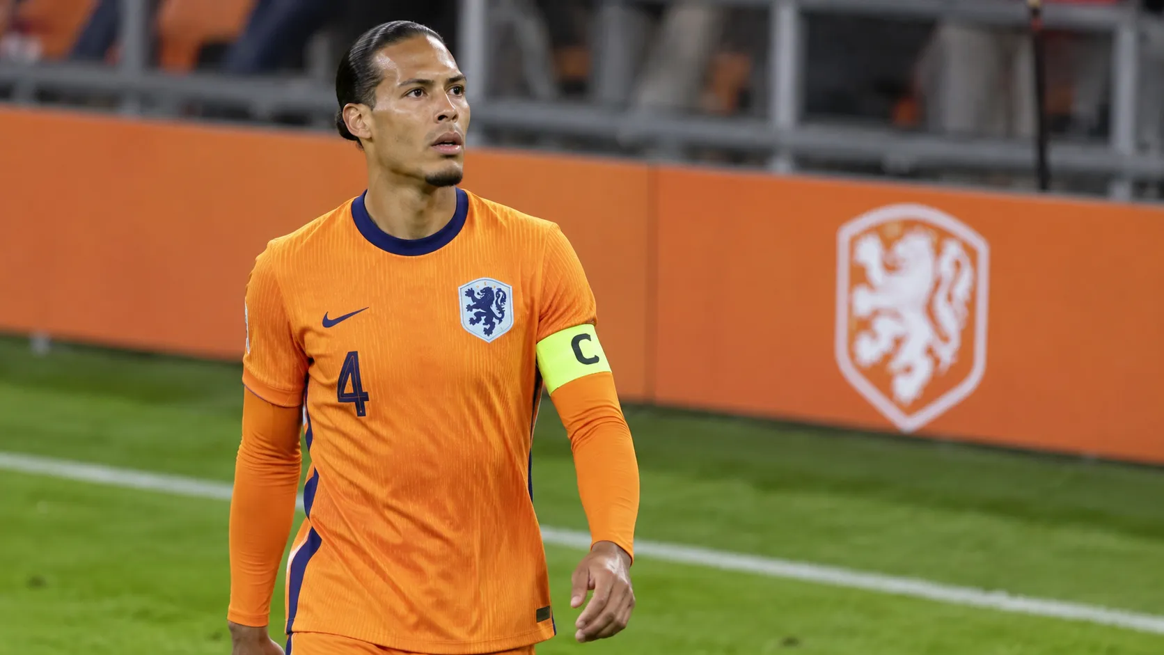 Virgil van Dijk in het tenue van Nederland met aanvoerdersband aan de rand van het veld.
