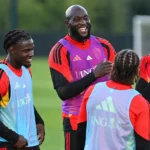 Een groep Belgische internationals en stafleden tijdens een ontspannen training op het veld.