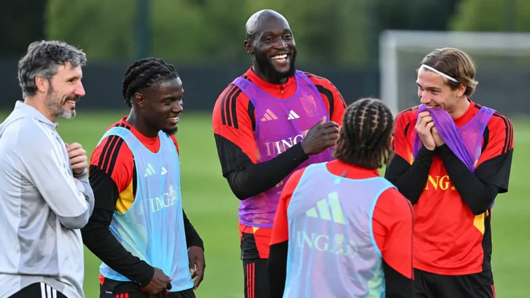 Een groep Belgische internationals en stafleden tijdens een ontspannen training op het veld.