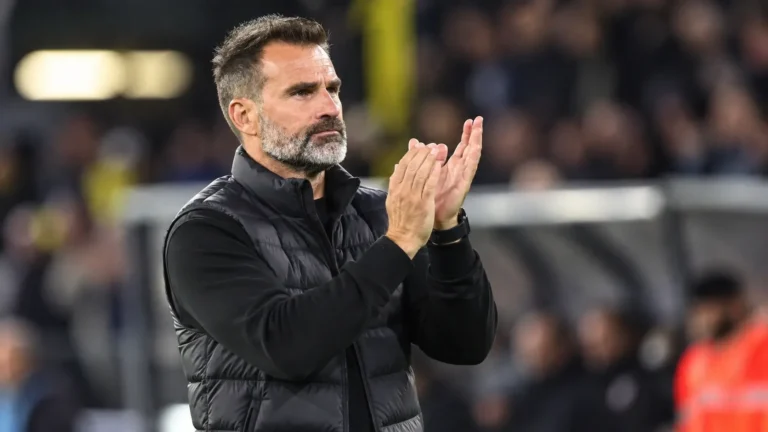 Ivan Leko applaudisseert langs de zijlijn van een voetbalveld.