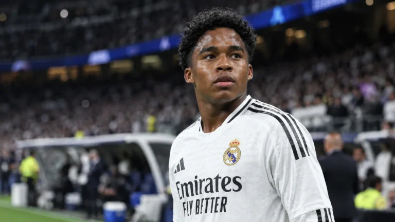 Endrick in het witte tenue van Real Madrid langs de zijlijn van een stadion.